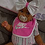 Symora is registered to the contest to win money with this photo: applique, baby, bib, bodypart, bonnet, clothing, couch, doll, face, finger, furniture, hand, hat, head, pattern, person, photography, portrait, sitting, toy