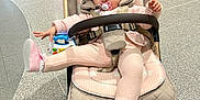 Natalia joined the competition — help win amazing prizes! baby, child, stroller, pink_clothing, headband, pacifier, toy, floor, playful, indoor, footwear, person, baby_shoes, seated, blanket, comfort, cute, infant, expression, casual