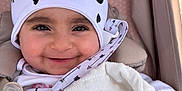 Natalia is registered to the contest to win money with this photo: baby, smiling, hat, blanket, stroller, child, face, clothing, cute, warm, comfort, infant, pink, white, pattern, mickey_mouse, heart, happy, closeup, portrait