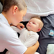 Lyric joined the competition — help win amazing prizes! affection, baby, bed, blanket, caring, child, closeup, face, family, head, holding, indoor, infant, interaction, love, pacifier, person, sitting, toddler, white_clothing