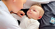 Lyric joined the competition — help win amazing prizes! affection, baby, bed, blanket, caring, child, closeup, face, family, head, holding, indoor, infant, interaction, love, pacifier, person, sitting, toddler, white_clothing