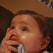 Lyric joined the competition — help win amazing prizes! baby, infant, child, portrait, close_up, face, eyes, wide_eyed, brown_hair, smiling, hand, parent, touching, blanket, clothing, indoors, cozy, couch, warm_lighting, photography