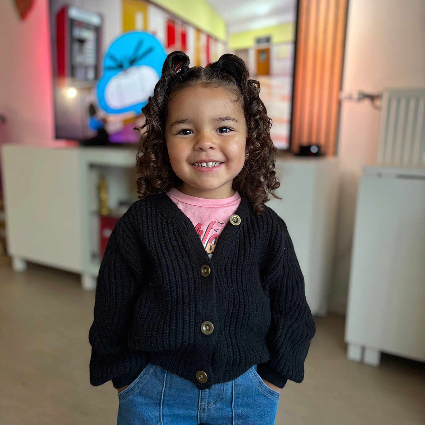 Célizia a rejoint le concours — aidez-le/la à gagner de superbes lots ! animated_character, background, black_cardigan, blue_jeans, cabinet, casual_clothing, child, curly_hair, curly_hair_style, cute, girl, hands_in_pockets, happy, indoor, pigtails, portrait, radiator, smile, television, wooden_floor