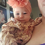 Eva joined the competition — help win amazing prizes! baby, child, flower_headband, floral_dress, person, adult, glasses, purple_top, lace, portrait, indoor, hand, skin, face, expression, photograph, decor, wall, frame, calm