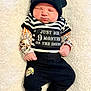 Lincoln is registered to the contest to win money with this photo: baby, sleeping, hat, striped_shirt, tattoo_sleeves, skull_design, black_pants, white_socks, blanket, infant, cute, clothing, portrait, indoors, child, newborn, resting, soft_texture, casual, fashion