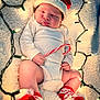 baby, infant, sleeping, santa_hat, candy_cane, christmas_lights, white_onesie, red_socks, holiday, festive, blanket, closeup, cute, celebration, newborn, soft_texture, holiday_theme, indoors, cozy, child