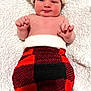 Lincoln is registered to the contest to win money with this photo: baby, infant, santa_hat, red_hat, plaid_pants, blanket, white_blanket, smiling, cute, holiday, christmas, festive, cozy, child, newborn, portrait, indoor, soft_texture, skin, hands