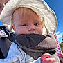 baby, child, infant, sun_hat, baby_carrier, outdoor, blue_sky, hand, face, person, clothing, closeup, daylight, cute, skin, adult, parent, nature, portrait, headwear