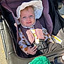 baby, child, stroller, sun_hat, blue_eyes, smile, seatbelt, autumn_clothing, outdoor, sunlight, happy, infant, person, portrait, cute, baby_clothes, hand, warm_clothing, daylight, seat