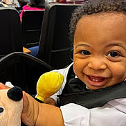 Aurelias is registered to the contest to win money with this photo: toddler, child, smiling, face, curly_hair, toy, plush_toy, mickey_mouse, clothing, white_shirt, black_bowtie, indoor, people, seated, happy, closeup, portrait, baby, fun, cute