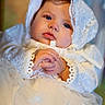 baby, infant, lace, white_dress, bonnet, hands, clasped_hands, portrait, closeup, soft_lighting, cute, child, face, young, indoors, serene, adorable, clothing, expression, newborn