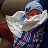 newborn, baby, infant, blanket, blue_hat, airplane_patch, hospital_blanket, wrapped, sleepy, cradled, couch, leather, person, indoors, cozy, child, cute, small, resting, baby_clothing