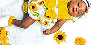 Rayneris joined the competition — help win amazing prizes! baby, infant, child, sunflower, yellow, white_blanket, flowers, headband, cute, smiling, lying_down, soft_texture, baby_clothes, footwear, bright_colors, portrait, indoors, happy, skin, baby_girl