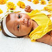 Rayneris joined the competition — help win amazing prizes! baby, infant, yellow_clothing, headband, flowers, blanket, lying_down, cute, child, portrait, close_up, soft_texture, floral_pattern, pacifier, skin, face, eyes, hand, adorable, bright_colors