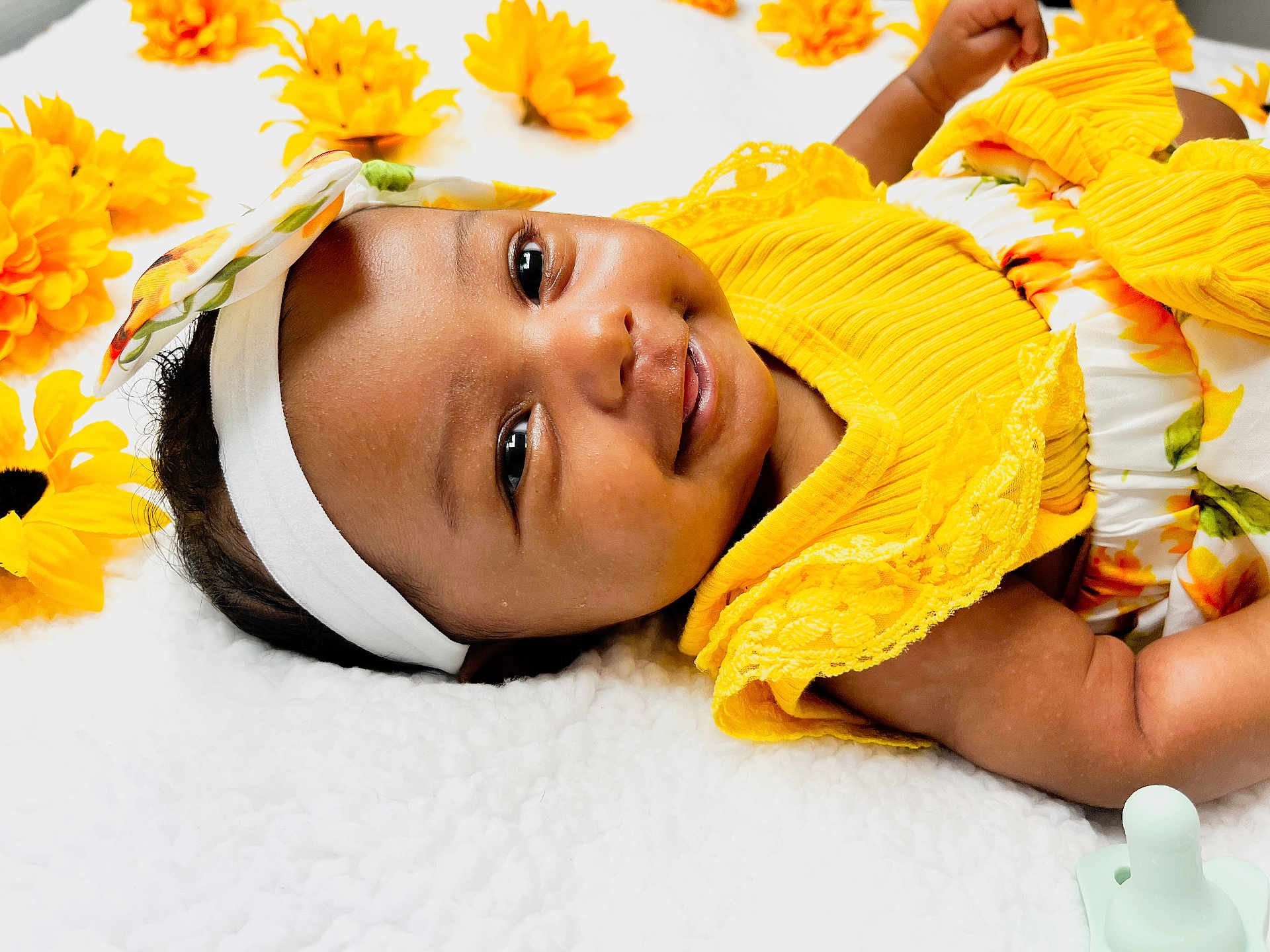 Rayneris joined the competition — help win amazing prizes! baby, infant, smiling, yellow_clothing, headband, flowers, blanket, happy, cute, portrait, closeup, skin, face, lying_down, child, toddler, indoors, soft_texture, bright_colors, pacifier