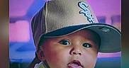 Sebastian is registered to the contest to win money with this photo: baby, child, face, cap, hat, portrait, closeup, indoors, curious, cute, expression, person, clothing, headwear, young, infant, casual, background, colorful, drool