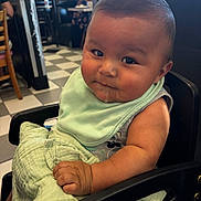 Sebastian joined the competition — help win amazing prizes! baby, child, high_chair, bib, blanket, drool, indoor, restaurant, diner, floor_tiles, person, curious, seat, table, window, casual_clothing, face, skin, arm, hair