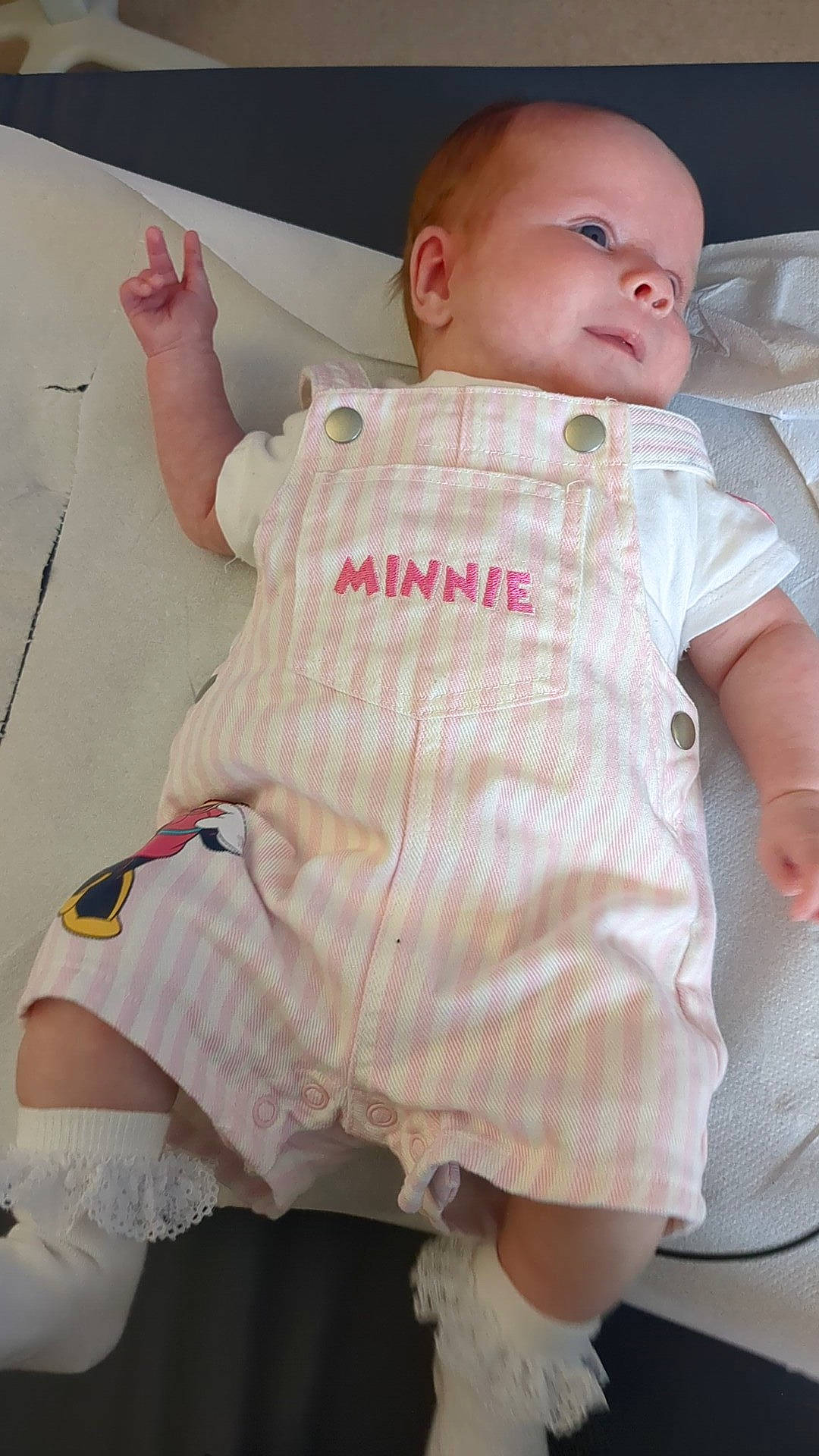 arm, baby, child, clothing, cute, fabric, face, footwear, frilly, hand, infant, legs, lying_down, minnie, pink_stripes, portrait, skin, socks, textile, white