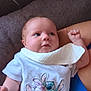 Dolly-Mae joined the competition — help win amazing prizes! baby, infant, bib, tshirt, cartoon, hugging, couch, arm, person, cute, smiling, clothing, fabric, indoor, child, young, skin, face, hand, relaxing