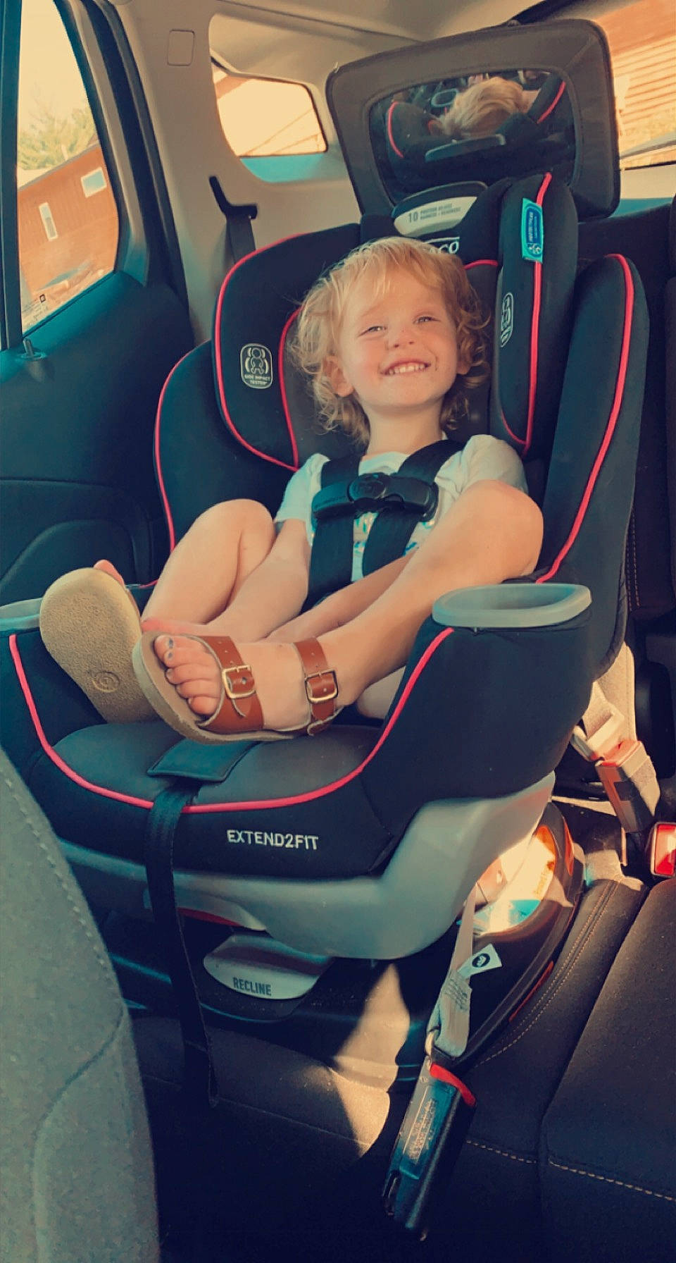 Sophia is registered to the contest to win money with this photo: auto_part, automotive_design, baby_products, car_seat, car_seat_cover, child, comfort, family_car, fun, head_restraint, joy, leisure, motor_vehicle, person, plant, product, seat_belt, sitting, smile, toddler