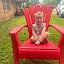 Ariel is registered to the contest to win money with this photo: toddler, child, red_chair, outdoor, grass, smiling, summer_clothing, sandals, house, window, lawn_equipment, car, pickup_truck, daytime, sky, greenery, person, portrait, happy, nature