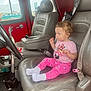 toddler, child, car_seat, leather_seat, pink_clothing, minnie_mouse, socks, curly_hair, vintage_car, steering_wheel, seatbelt, window, red_interior, gray_seat, floor_mat, car_door, interior, side_view, person, casual