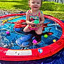 Ariel is registered to the contest to win money with this photo: toddler, child, splash_pad, water, toy, outdoor, grass, sunny, play, smile, happy, summer, colorful, water_fountain, pool, clothing, person, backyard, fun, spiderman