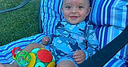 Jeremiah joined the competition — help win amazing prizes! baby, child, smiling, toys, chair, cushion, blue_stripes, outdoor, grass, woman, garden, furniture, person, happy, playing, summer, casual_clothing, relaxing, daytime, seat