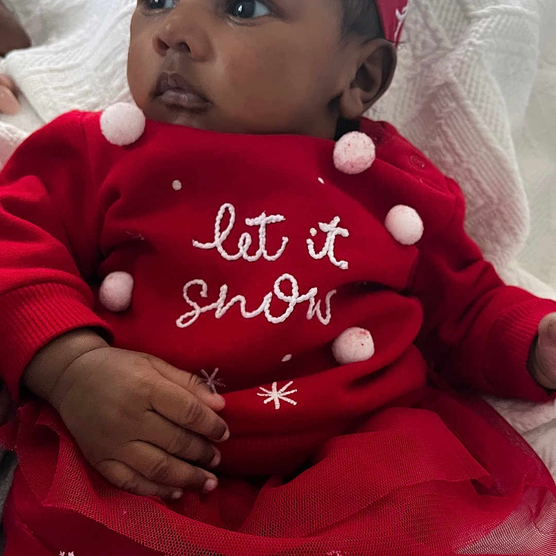 Asani is registered to the contest to win money with this photo: baby, blanket, child, cozy, cute, expression, face, festive, headband, holiday, indoors, infant, pom_poms, portrait, red_clothing, sitting, soft_texture, toddler, warm, white_socks