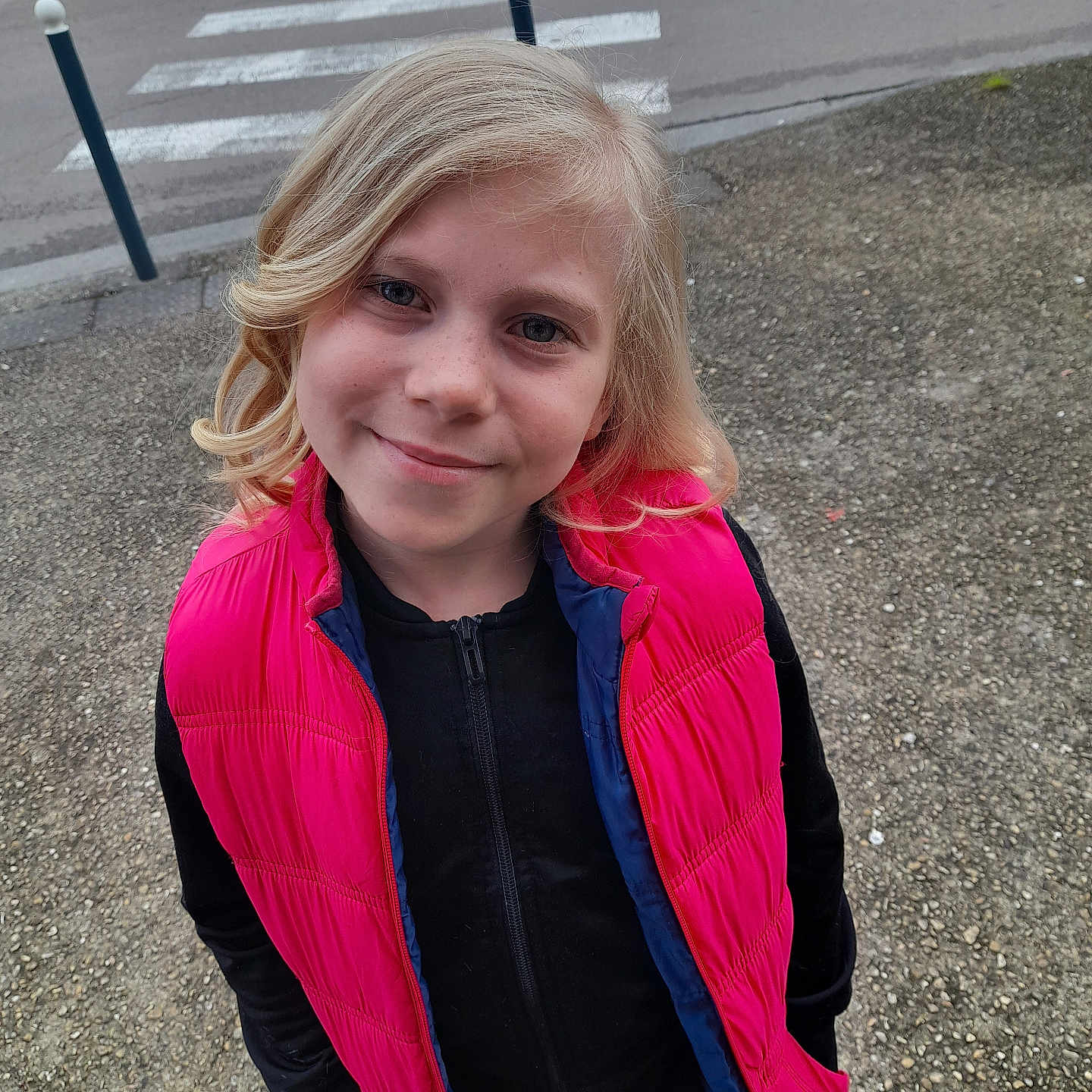 Victoria a rejoint le concours — aidez-le/la à gagner de superbes lots ! blonde, child, clothing, coat, face, female, girl, gravel, hair, head, jacket, knitwear, longsleeve, person, road, slate, sleeve, sweater, tarmac, zebracrossing
