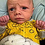 Zane joined the competition — help win amazing prizes! baby, infant, face, yellow_onesie, blanket, clothing, newborn, hands, expression, portrait, indoor, cute, skin, wrinkles, eyes, head, young_child, soft_texture, cozy, sleepwear