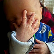 Zane is registered to the contest to win money with this photo: baby, infant, hand, face, pajamas, sleeping, cute, child, newborn, skin, fingers, covering_face, closeup, soft_light, indoors, colorful_clothing, sleepy, peaceful, person, young_child