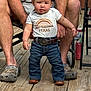 toddler, child, baby, texas, tshirt, jeans, belt, boots, hands, adult, wooden_deck, floor, person, outdoor, legs, clothing, footwear, expression, standing, support