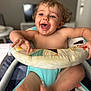 toddler, baby_walker, smiling, happy, indoor, child, colorful, patterned, arms, legs, seat, furniture, person, skin, hair, playful, joyful, expression, excitement, home