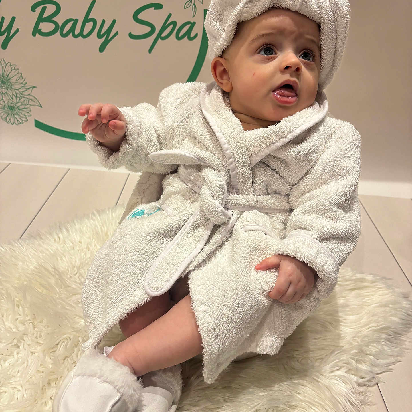 Leo is registered to the contest to win money with this photo: baby, blanket, bodypart, bonnet, clothing, face, fashion, finger, hand, hat, head, hood, knitwear, newborn, person, photography, portrait, robe, sitting, towel