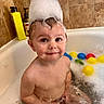 toddler, bath, foam, bubbles, water, tub, toy, child, splashing, bathroom, tiles, yellow_bottle, red_bottle, colorful_balls, cute, smiling, wet, playful, skin, head