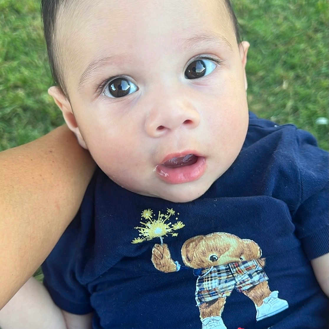 Noah joined the competition — help win amazing prizes! baby, infant, child, outdoor, grass, person, navy_shirt, bear_design, cute, wide_eyes, curious, hand, arm, digital_sticker, hearts, cartoon, holding, portrait, casual_clothing, young