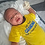 baby, infant, yellow_shirt, crib, blanket, mittens, smile, face, child, cute, lying_down, comfort, soft, indoors, toddler, happy, clothing, person, young_child, expression