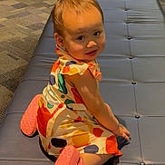 Reese is registered to the contest to win money with this photo: toddler, child, dress, colorful_clothing, pink_shoes, sitting, bench, leather_bench, indoor, carpet, patterned_carpet, smiling, looking_back, short_hair, cute, young_child, person, floor, playful, baby