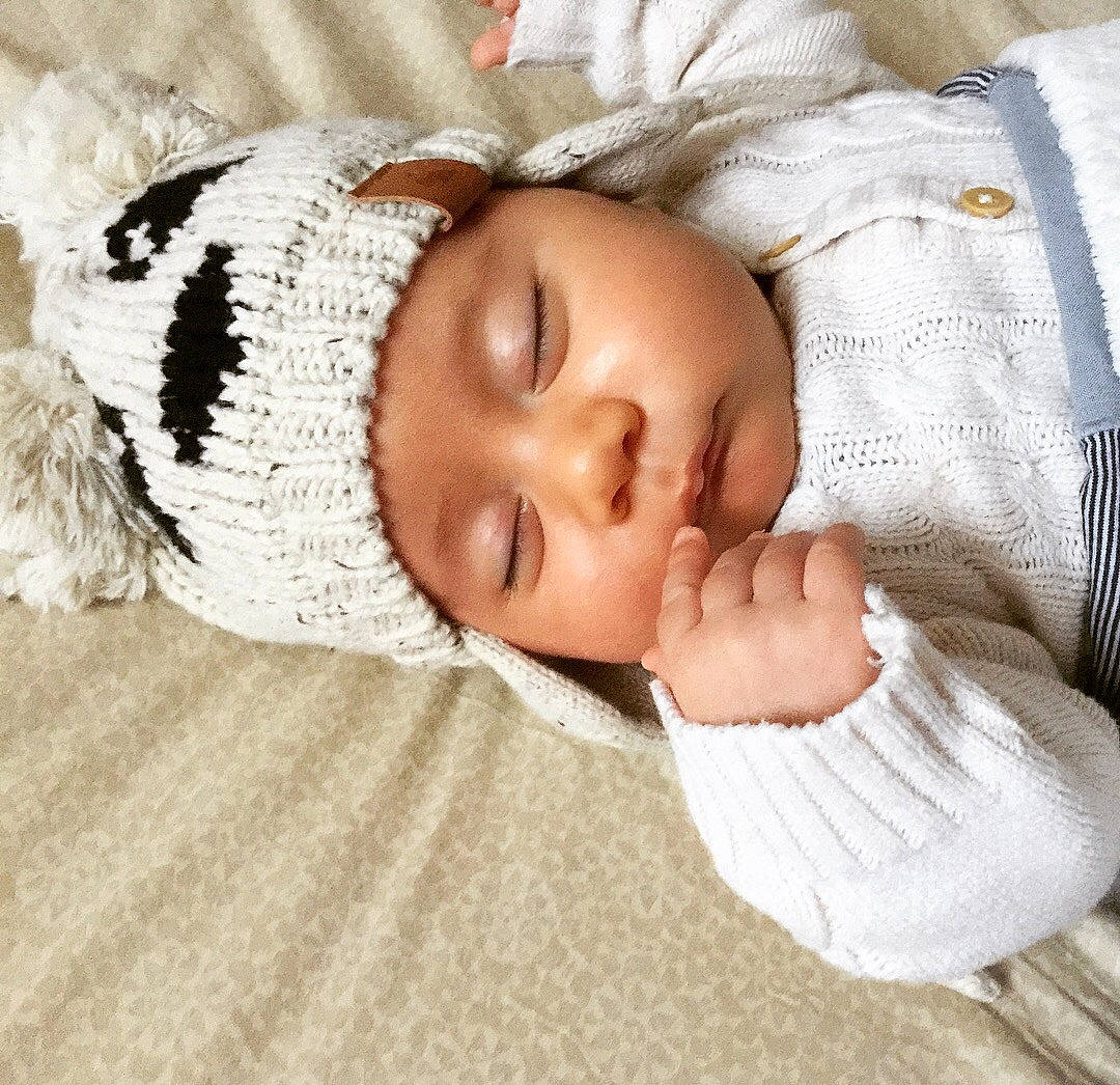 Alec participe au concours pour gagner de l'argent avec cette photo : blanket, bonnet, child, headgear, infant, knit_cap, material, person, sleep, textile, wool