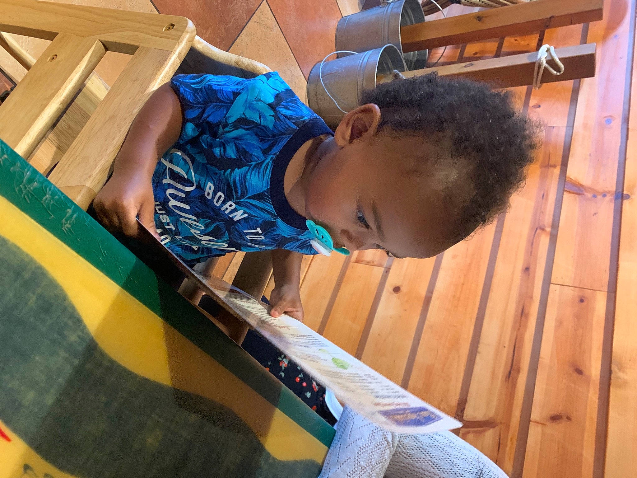 Zeus is registered to the contest to win money with this photo: child, electric_blue, flooring, fun, hardwood, leisure, person, play, recreation, room, sitting, t_shirt, tints_and_shades, toddler, wood