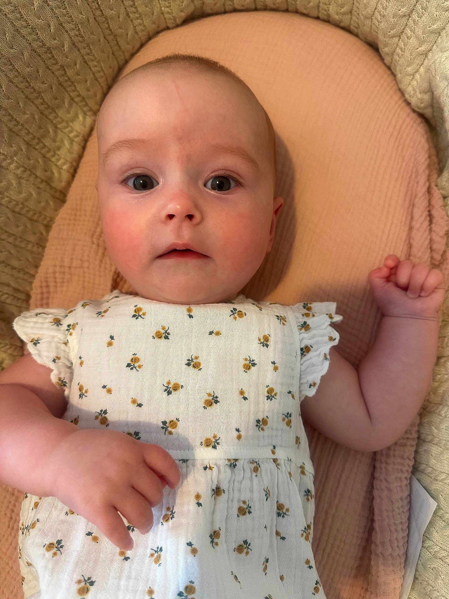 Bonnie joined the competition — help win amazing prizes! baby, infant, face, eyes, hand, dress, floral_pattern, blanket, texture, soft, skin, cute, lying_down, curious, young_child, portrait, indoor, closeup, apparel, child