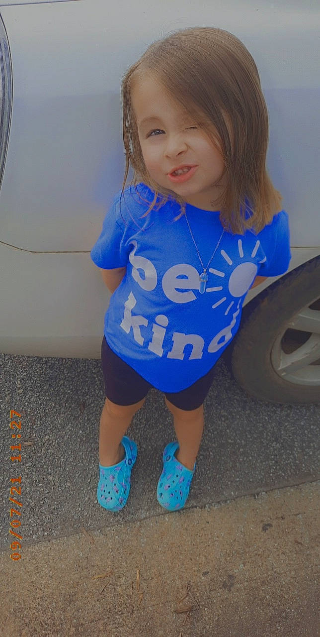 Paisley joined the competition — help win amazing prizes! arm, automotive_tire, azure, baby_toddler_clothing, blue, dress, eye, face, facial_expression, hairstyle, hand, happy, iris, person, skin, sleeve, smile, standing, t_shirt, tire