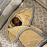 Jakai is registered to the contest to win money with this photo: baby, bassinet, bed, blanket, blue_clothing, closed_eyes, cozy, face, indoor, infant, newborn, nursery, pacifier, patterned_bedding, photography, portrait, resting, sleeping, swaddled, yellow_blanket