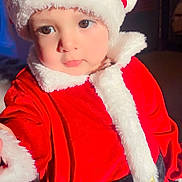 Reyansh joined the competition — help win amazing prizes! black_belt, child, christmas, curious_expression, cute, face, festive, holiday_costume, holiday_season, indoor, person, portrait, reaching_hand, red_clothing, santa_hat, soft_light, toddler, warm_colors, white_fur_trim, young_child