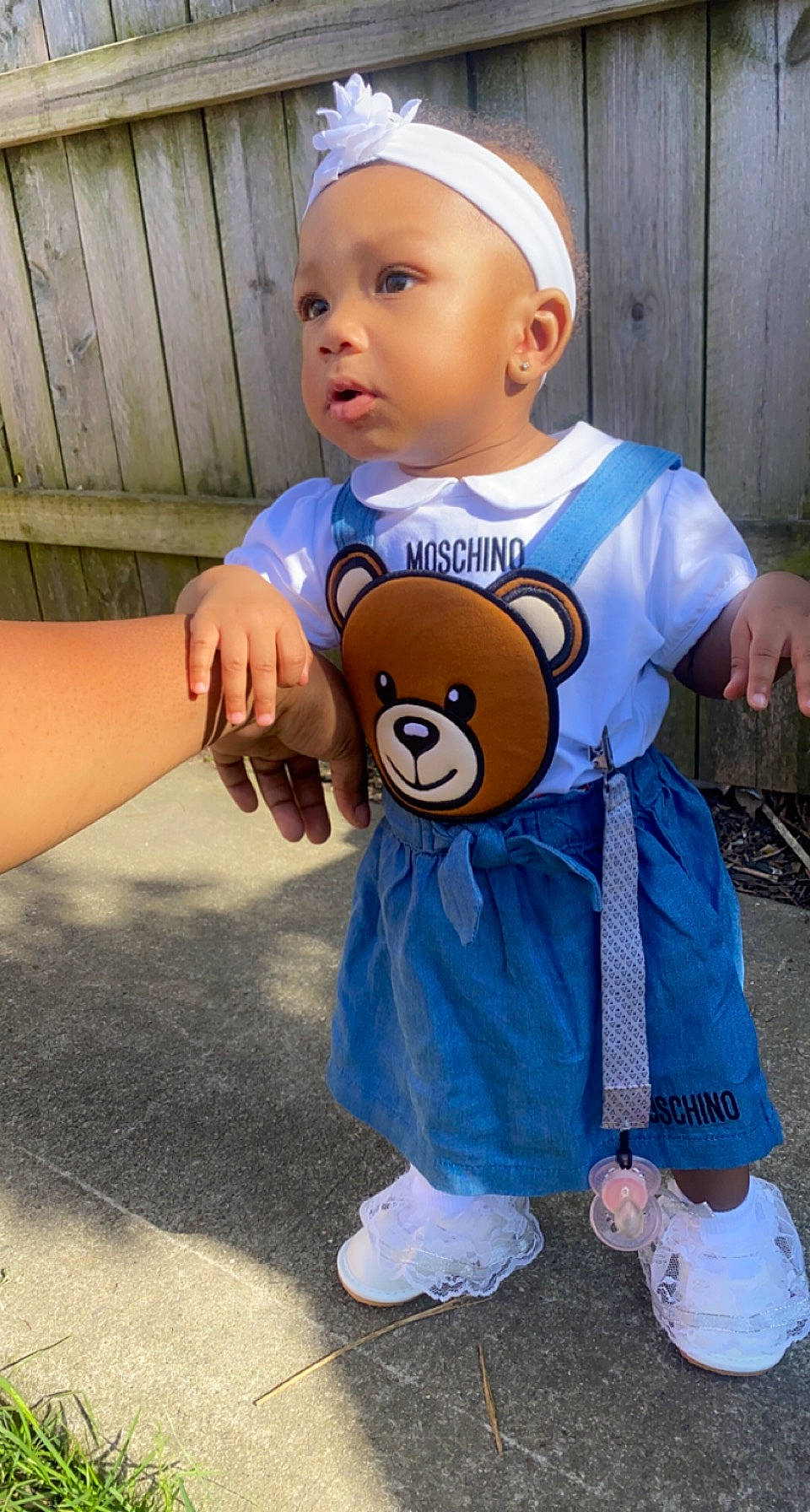 Kirah is registered to the contest to win money with this photo: baby, baby_toddler_clothing, cap, child, electric_blue, fun, fur, gesture, happy, head, headgear, headwear, person, personal_protective_equipment, recreation, standing, t_shirt, teddy_bear, thumb, toddler
