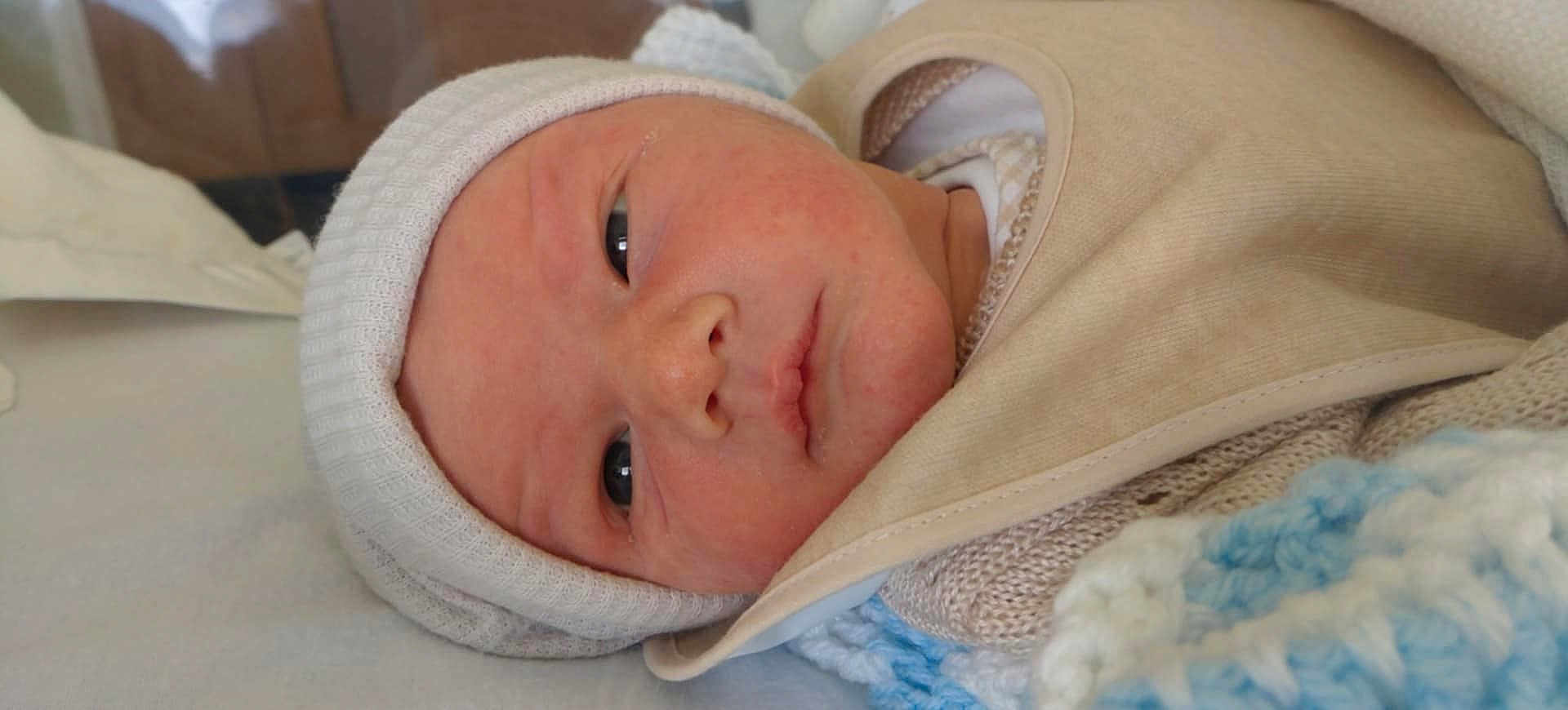Tobbie is registered to the contest to win money with this photo: baby, newborn, infant, face, hat, blanket, knit, closeup, portrait, sleeping, young, child, cute, soft, cozy, indoors, resting, skin, headwear, warm