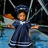 J'Alani is registered to the contest to win money with this photo: child, toddler, portrait, standing, sailor_dress, navy_blue, bonnet, curly_hair, wide_eyes, surprised_expression, outdoor_light, indoor, window, houseplant, carpet, sandals, fashion, full_body, smiling, adorable