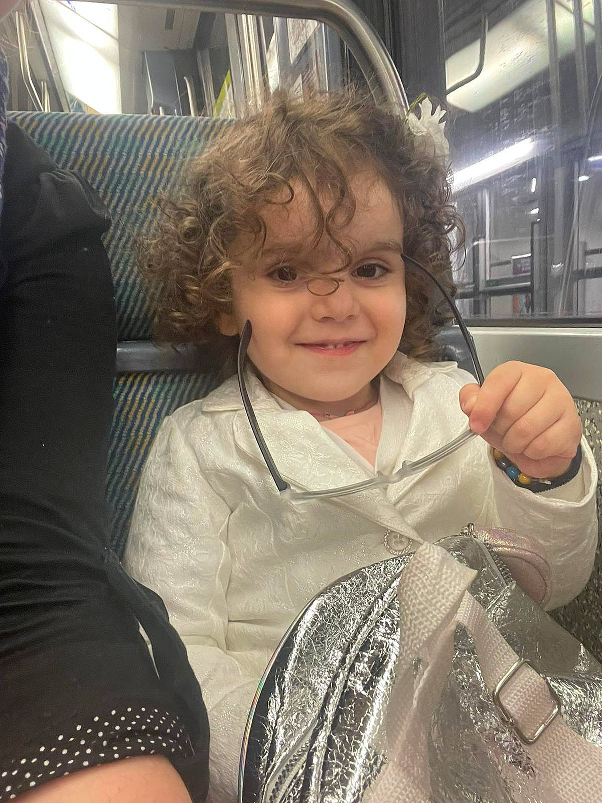 Anaëlle participe au concours pour gagner de l'argent avec cette photo : baby_toddler_clothing, blond, cheek, child, comfort, cool, fun, happy, iris, joy, pattern, person, sitting, skin, sleeve, smile, t_shirt, thumb, toddler, travel