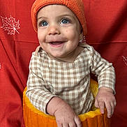 Kehlani joined the competition — help win amazing prizes! baby, child, pumpkin, hat, orange, smile, happy, knitted, autumn, fall, background, face, cute, hands, checkered_clothing, seasonal, festive, portrait, sitting, holiday